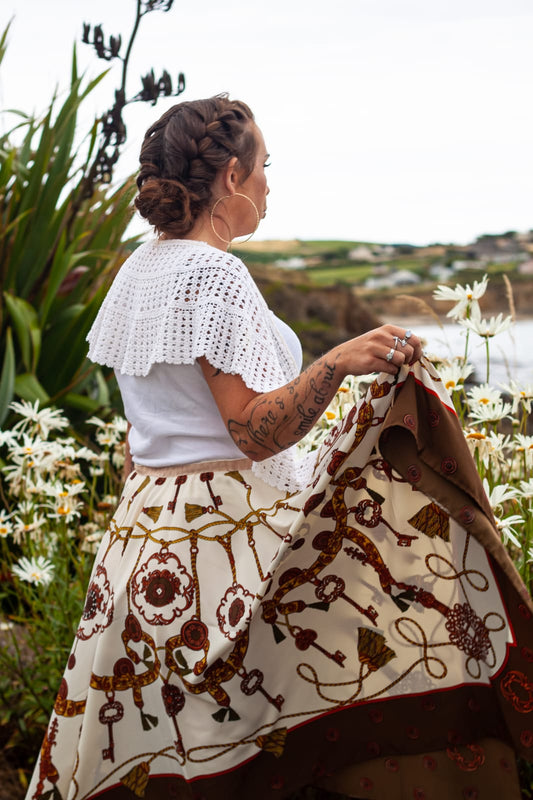 Model wears reworked vintage silk skirt while looking out to sea